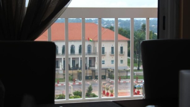 Habitació amb vista a un edifici amb teulada vermella i una bandera.