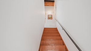 A staircase with wooden steps and a metal handrail, leading to a landing with a framed picture on the wall. - Casa Gallizza con Vista Mare by Wonderful Italy (Cefalù)