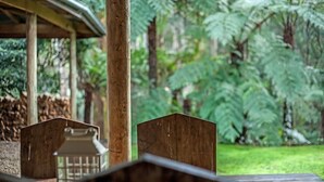 A wooden deck with a simple, rustic design, surrounded by lush greenery and ferns. - Memorable Gatherings at FernglenForestRetreat (Mount Dandenong)