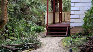 A pathway leading to a wooden gazebo in a garden with ferns and a white building. - Memorable Gatherings at FernglenForestRetreat (Mount Dandenong)