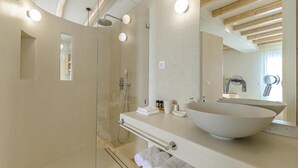 A modern bathroom with a glass-enclosed shower, a large vessel sink, and a mirror above the sink. - Supreme Suite with Spa Bath (Naxos)