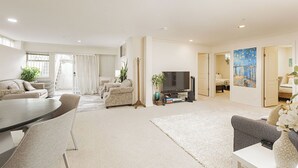 A living room with a sofa set, a coffee table, a TV, and a painting on the wall. - ❤️Spacious Home in Heart of Vancouver--Easy Access to Everything❤️ (Vancouver)