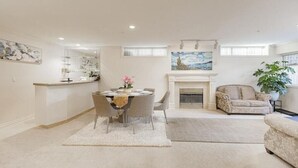 A spacious living room with a fireplace, a dining area, and a kitchen counter. - ❤️Spacious Home in Heart of Vancouver--Easy Access to Everything❤️ (Vancouver)