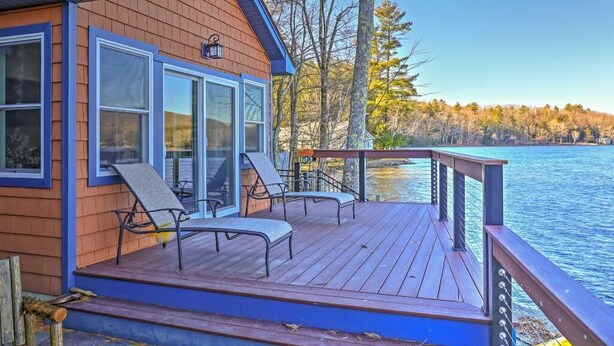 A cabin with a deck overlooking a lake, featuring large windows and two lounge chairs. - Waterfront Cottage 10 Min From Great Barrington (New Marlborough)