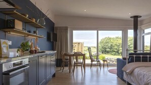 Eine moderne Küche mit Essbereich und ein Schlafzimmer mit großem Fenster.