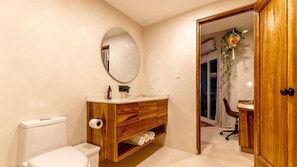 Une salle de bain avec des toilettes, un meuble-lavabo en bois et un miroir.