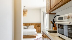 Una cocina moderna con armarios de madera, encimera blanca y horno empotrado.