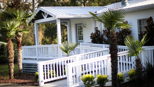 A white house with a covered porch and a fenced deck area. - All You Ever Wanted "The White House" (Columbia County)