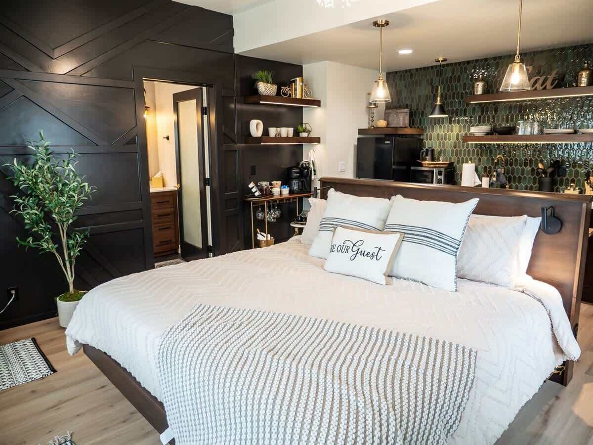 Een moderne slaapkamer met een groot bed, nachtkastjes en een potplant.