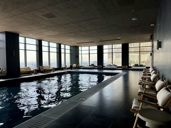 Una piscina techada, sillones reclinables de piscina