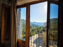 Habitación con un amplio ventanal que ofrece vistas a un paisaje montañoso.