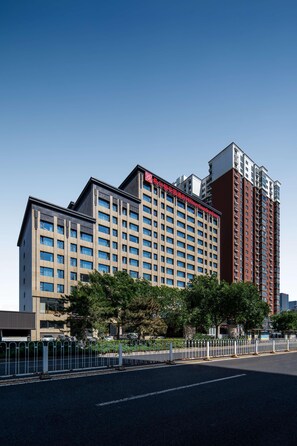 A multi-story hotel with a modern design, featuring a prominent red sign on the top. - Hilton Garden Inn Beijing West Railway Station (Beijing)