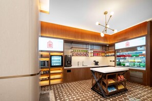 A modern kitchen with a microwave, coffee machine, and a refrigerator stocked with beverages. - Hilton Garden Inn Beijing West Railway Station (Beijing)