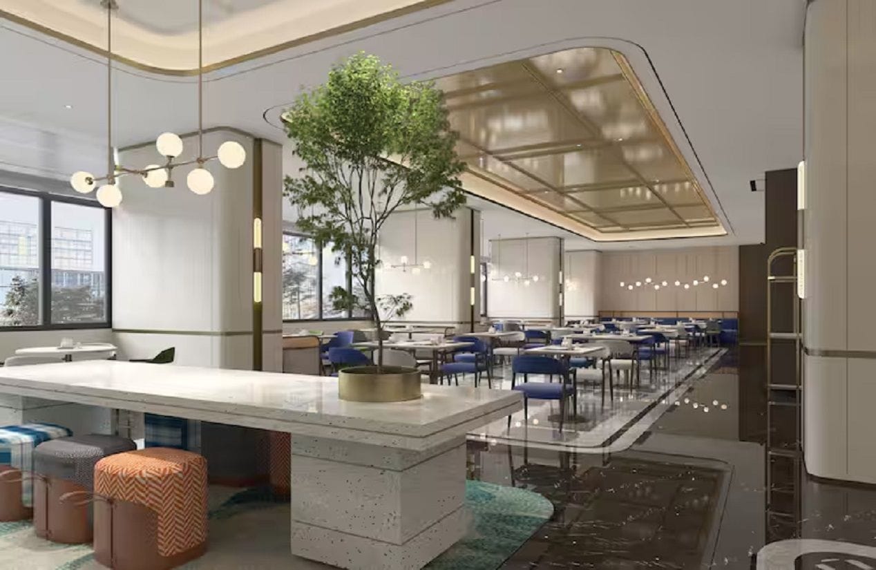 Un comedor moderno con una isla central, sillas azules y un árbol grande.