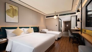 Habitació d'hotel amb dos llits, un escriptori i una cadira.