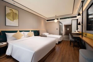 Ein Hotelzimmer mit zwei Betten, einem Schreibtisch und einem Stuhl.