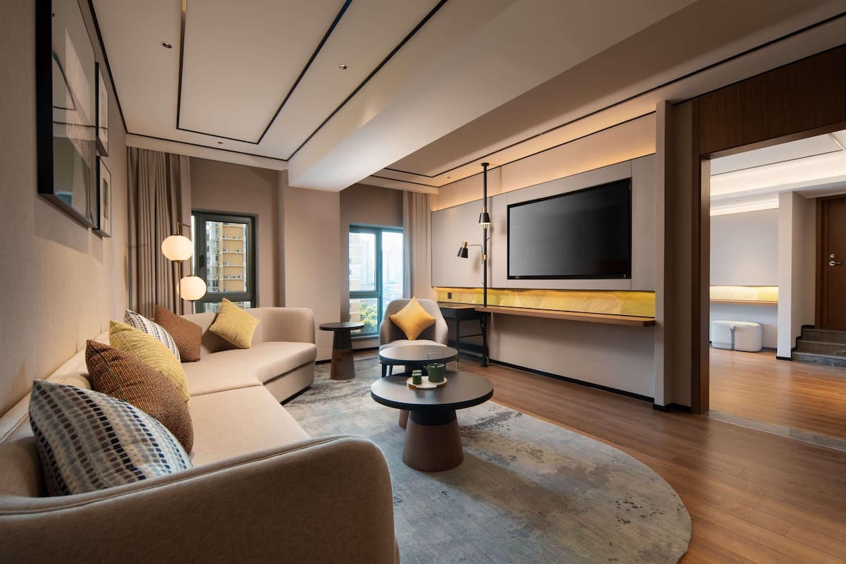 Una sala de estar moderna con sofá, mesa de centro y televisor.