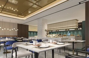 A modern restaurant with high tables and chairs, a central decorative pillar, and a kitchen area in the background. - Hilton Garden Inn Beijing West Railway Station (Beijing)