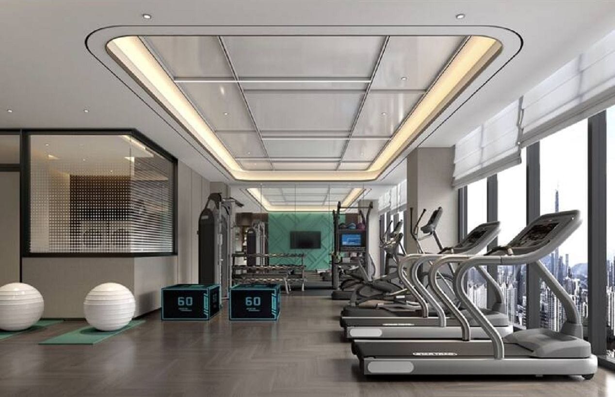 Un gimnasio moderno con cintas de correr, pelotas de ejercicio y un reloj digital.