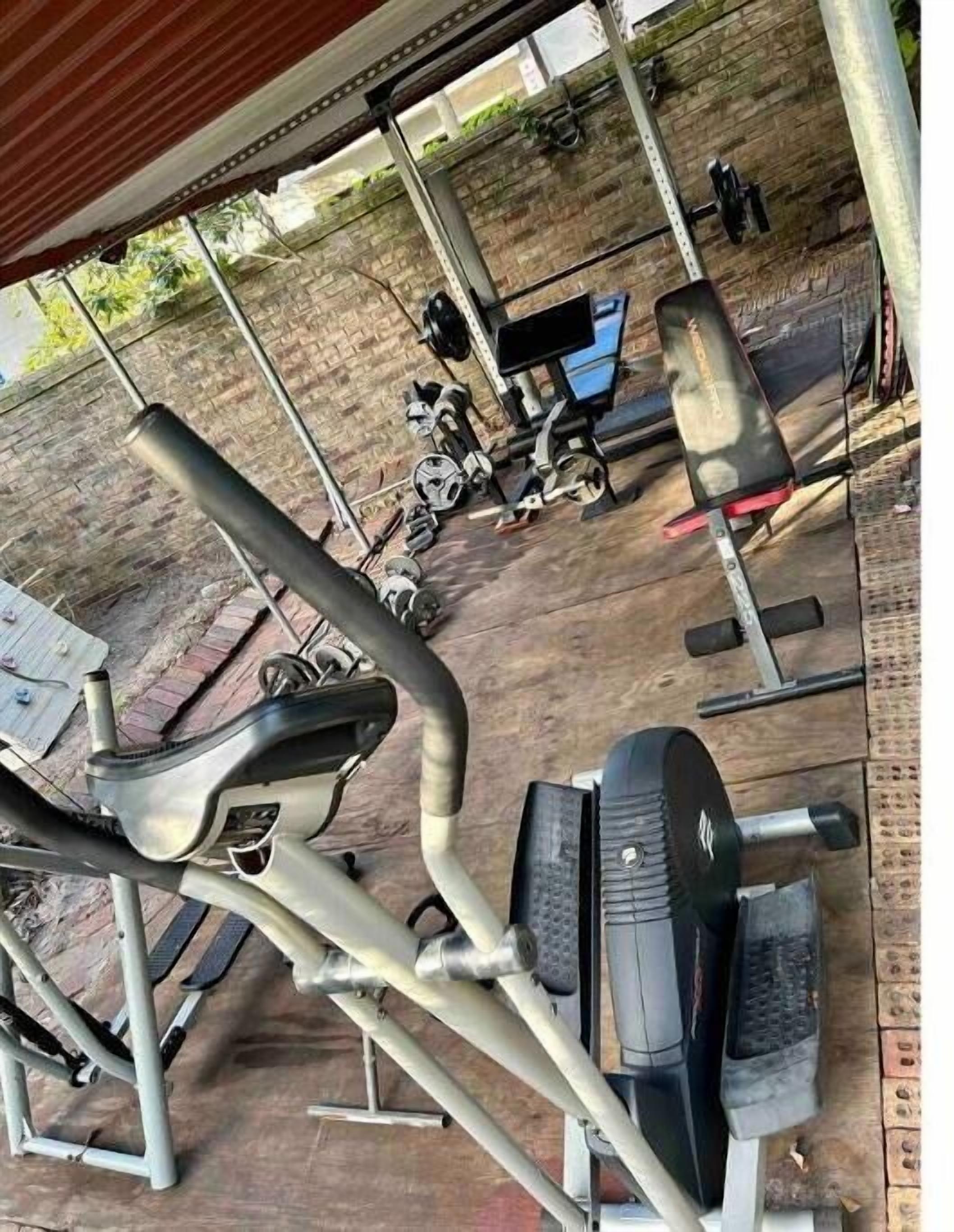 A gym with exercise equipment including treadmills, weight machines, and free weights.