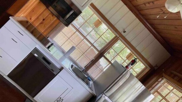A compact kitchen with white cabinets, a built-in oven, and a ceiling fan. - Peaceful Private Gated Patio Walk to Mall Publix

 (Altamonte Springs)