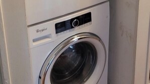 Eine Whirlpool Wasch- und Trockner-Kombination steht in einer Ecke des Raumes.