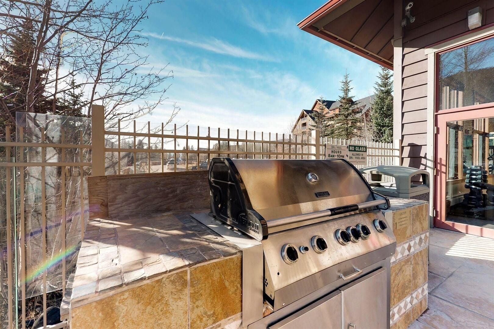 Ein Grill für den Außenbereich mit Schornstein, einer Glaskuppel und einer Steinsockel.