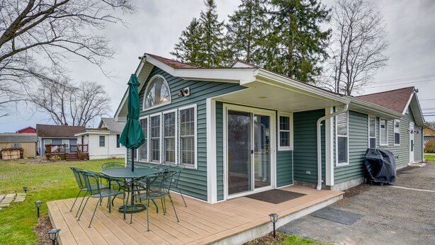 A single-story house with a covered patio, a sliding glass door, and a green umbrella. - Angola Getaway: Walk to Lake Erie Beach Park! (Angola)