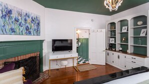 Una sala de estar moderna con chimenea, televisor y estantería.