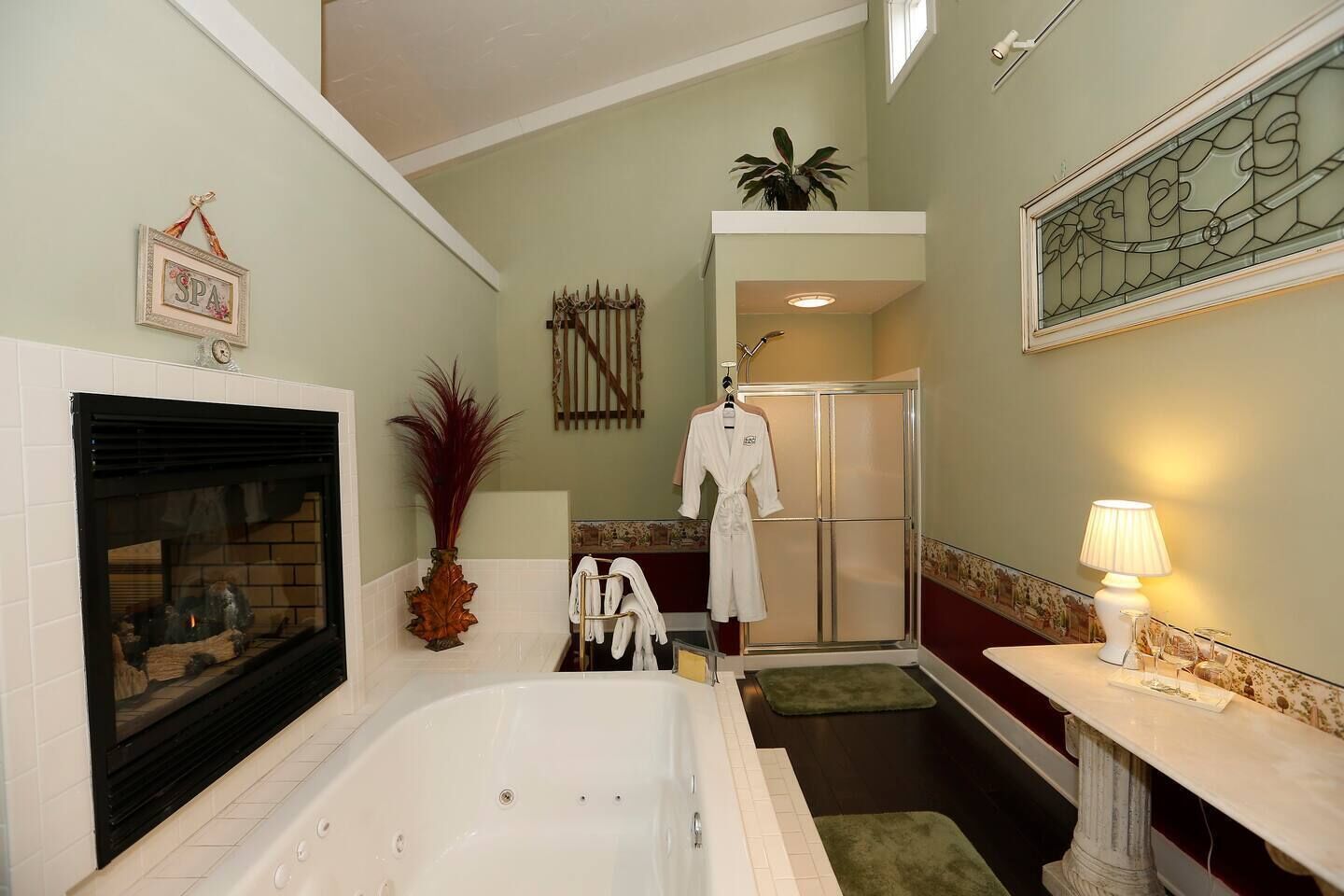 Ein Badezimmer mit einer Badewanne, einer Dusche, einem Kamin und einem Waschtisch mit einer Lampe.