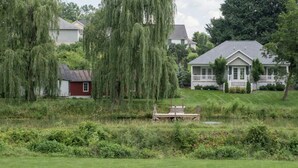 A residential area with houses, a pond, and a wooden dock.