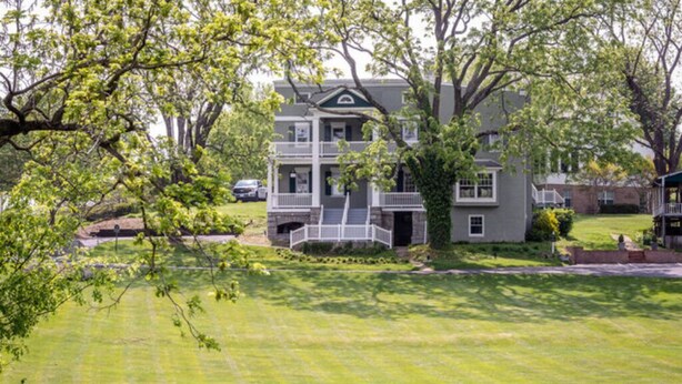 A two-story house with a front porch, a lawn, and trees. - The Sugar Maple - Suite (Harrisonburg)