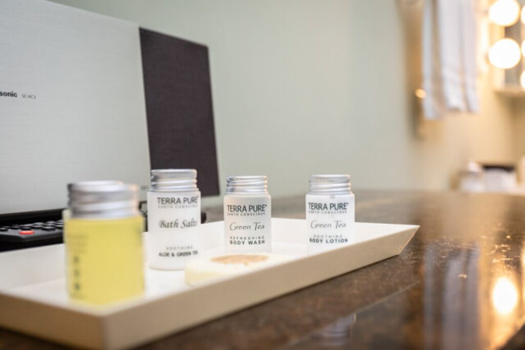 Una bandeja con tres botellas de productos de baño Terra Pure sobre una encimera.