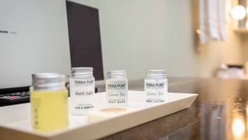 Una bandeja con tres botellas de productos de baño Terra Pure sobre una encimera.
