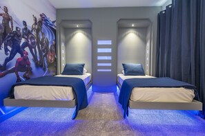 Une chambre d’hôtel avec deux lits, une fresque murale et un panneau de commande éclairé.