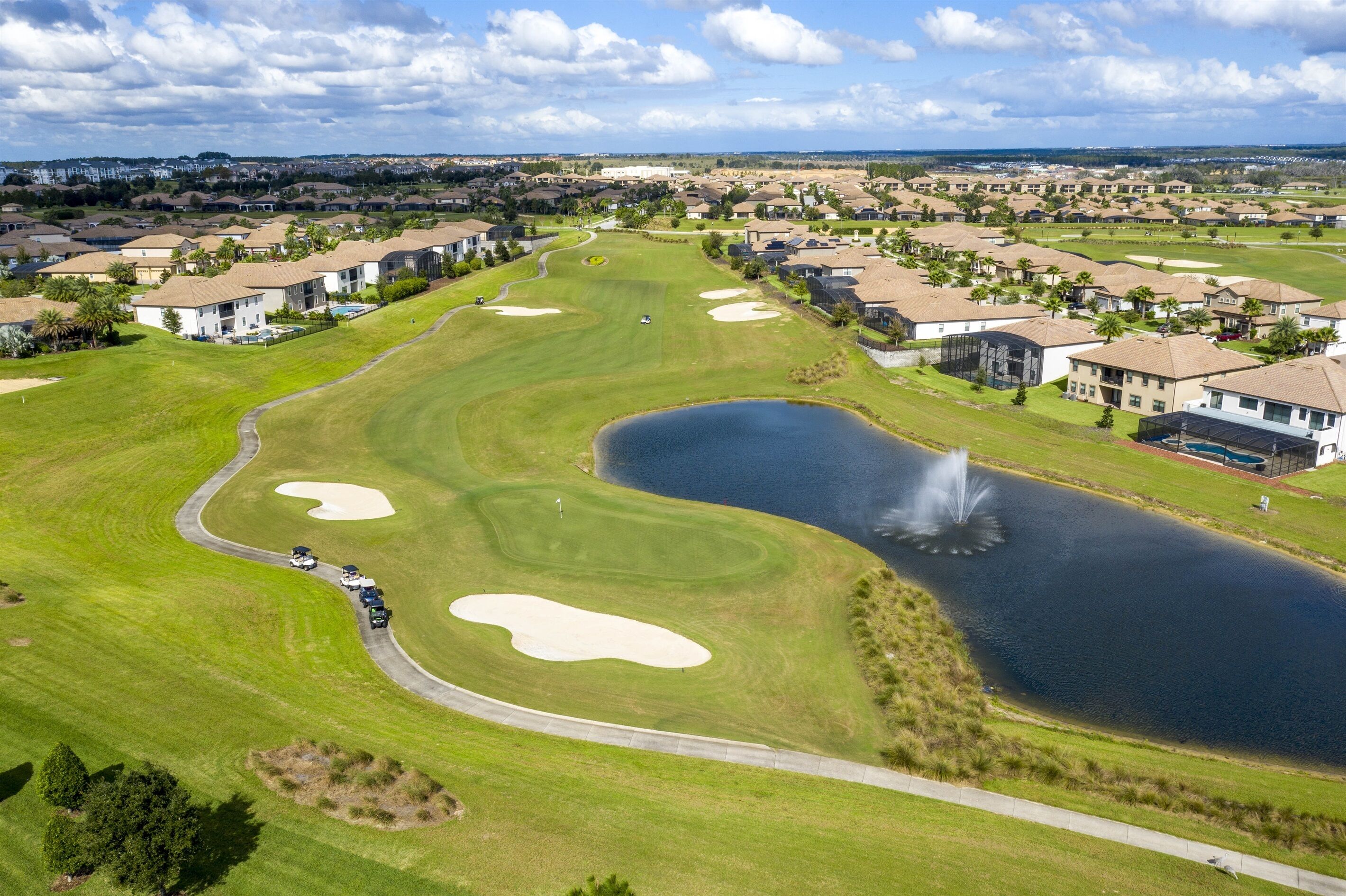Un parcours de golf doté de bunkers, d’un étang et d’une fontaine.