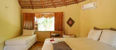 A room with two beds, a window with curtains, a ceiling fan, and a wall-mounted air conditioner.