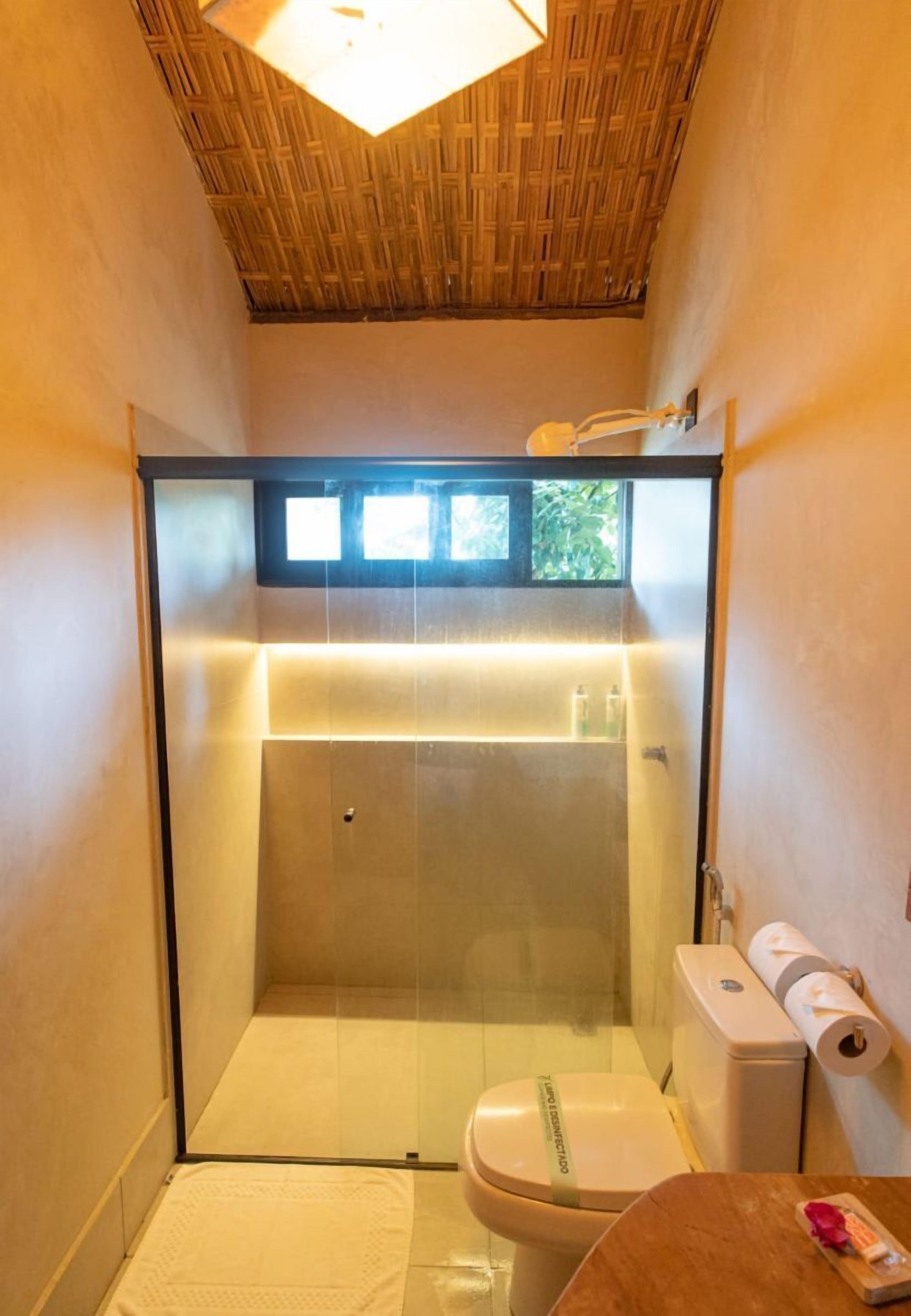 A small, modern bathroom with a glass-enclosed shower, a toilet, and a sink.