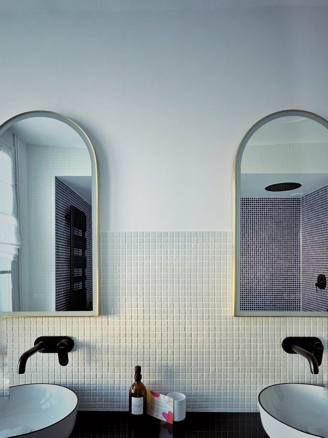 Une salle de bain avec deux lavabos, un miroir et un porte-serviettes.
