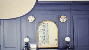A dark blue, ornate dresser with a mirror and two wall-mounted lamps. - Maison D'hôte - Chambre Double Kaolin (LIMOGES)