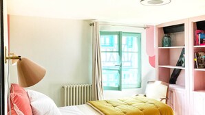 Une chambre avec deux lits, un radiateur, une fenêtre avec des rideaux et une bibliothèque.