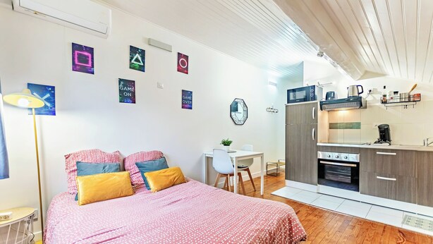 A modern bedroom with a bed, bedside table, and a desk with a chair. - Cosy air-conditioned studio with secure parking (Lyon)