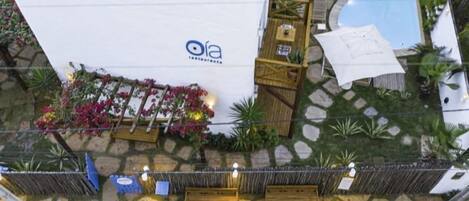 A rooftop terrace with a pool, outdoor seating, and a restaurant sign.