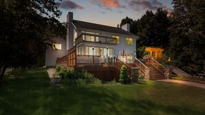 Une maison à deux étages dotée d’une terrasse, d’un escalier et d’un petit espace extérieur aménagé pour s’asseoir.