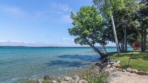 Une vue sur le lac, avec une eau claire, une plage de sable et des arbres.