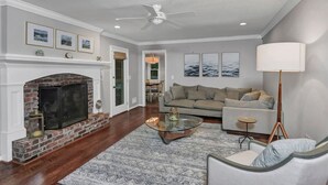 A living room with a fireplace, a sofa, a coffee table, and a lamp. - The Quail's Nest of Harbison | Sleeps 8 (Columbia)