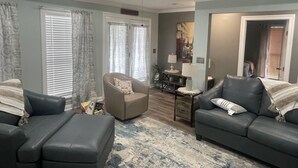 A living room with a ceiling fan, two sofas, a coffee table, and a rug.