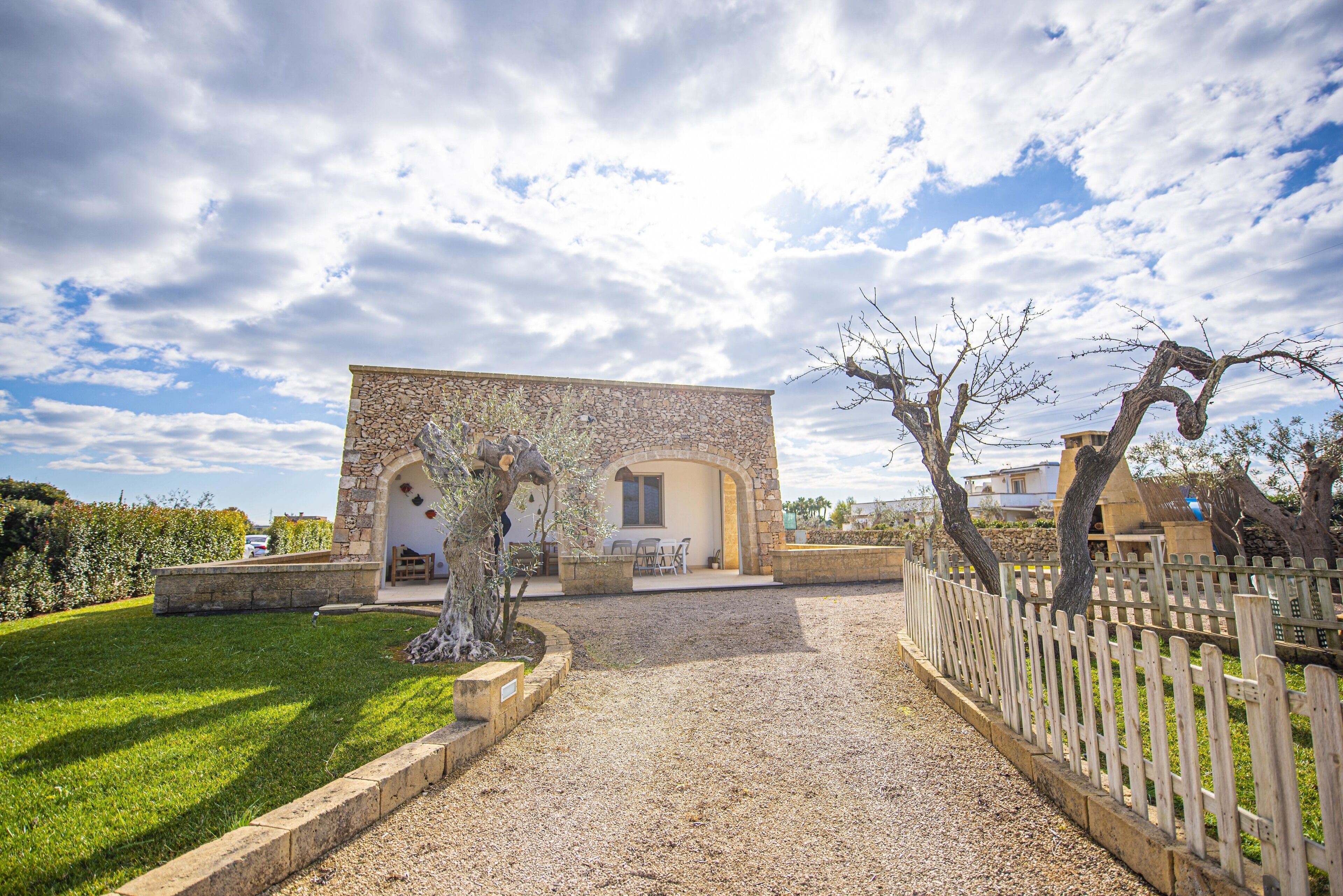 A stone building with a patio and a gravel path leading to it.