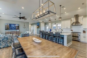 Enjoy meals in the spacious kitchen and dining area, featuring a central island and bar stools.