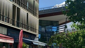 A modern urban setting with a multi-story building featuring a grid-like facade. - Studio 26 m2, à 5 mn de Paris (Arcueil)